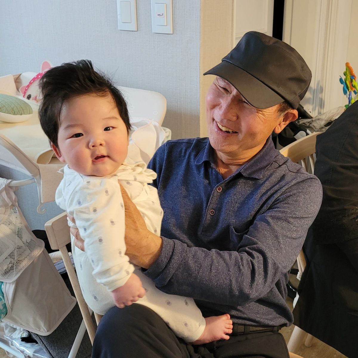 아버지가 손주를 안고 웃고 계신 모습